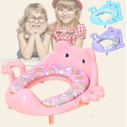Asiento entrenador para inodoro infantil con agarraderas, base antideslizante y superficie acolchada. Disponible en varios colores.