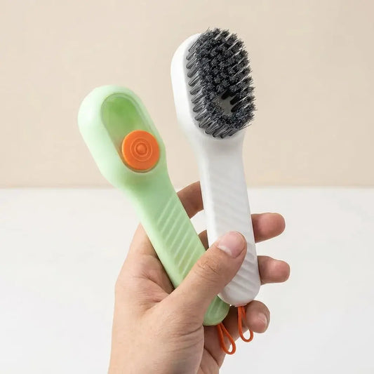 Cepillo limpiador con dispensador de jabón y gancho adhesivo. Ideal para lavar zapatos, ropa, cocina y baño con mayor facilidad.