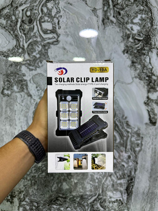 Lámpara solar LED con sensor de movimiento, recargable USB tipo C y clip. Ideal para iluminación práctica en interiores y exteriores.